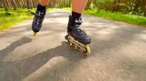 Put your body in a seating position. Outdoor Shuffle Inline Skating And T Braking Mans Legs Roller Skating On Forest Asphal Path Close