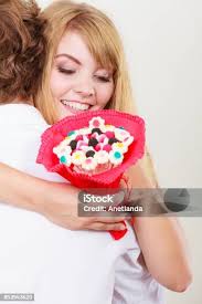 Couple With Candy Bunch Flowers Hugging Love Stock Photo