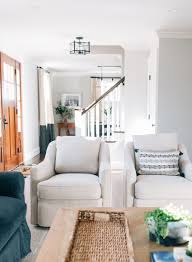 living room with ivory cream off white swivel chairs and blue sofa and long rustic reclaimed table white swivel chairs living room grey oak