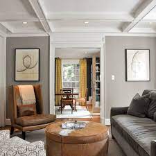 Tapestry style fabrics on accent pillows in beige and gold pair elegantly with traditional style brown leather sofas and chairs. Wall Color Gray Living Room Design Living Room Grey Grey Walls Living Room