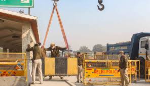 A farmer holding a flag walks towards delhi after he and others broke the police barricade at singhu border during the tractor rally on republic day, in new delhi. Farmers Protest Continues To Grow Amid Centre S Call For Talks Orissapost