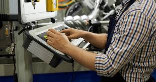 Operator produksi sedang bekerja di area manufaktur modern