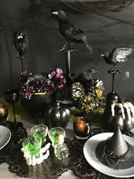 A halloween centerpiece of black cheesecloth, glitter skulls, gilded skeleton hands, black wax a black cardboard tree with pumpkins, blackbirds, skeletons and hay is a creative halloween decoration or centerpiece. Diy Halloween Decorations Diy