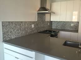 This kitchen is also a good example of a situation where some form of trim would be necessary. Marble Mosaic Herringbone Pattern With Schluter Trim Metallic Backsplash Contemporary Backsplash Backsplash