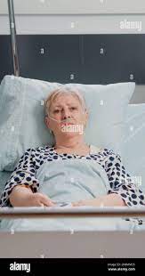 POV of aged woman with sickness talking on video call for remote  communication, laying in hospital