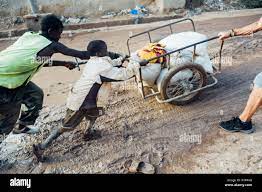 Mali, Africa - Caucasian Mature Man Help Black Children Carrying Food Is A  Vital Activity In An African Village Like Djenne Stock Photo - Alamy
