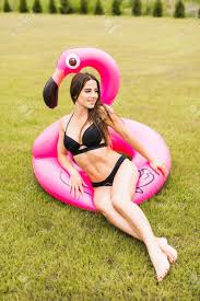 Fille Jeune Et Sexy S Amuser Et Rire Et S Amuser Sur L Herbe Pres De La Piscine Sur Un Flamant Rose Rose Gonflable En Maillot De Bain Et Lunettes De Soleil En Ete Banque