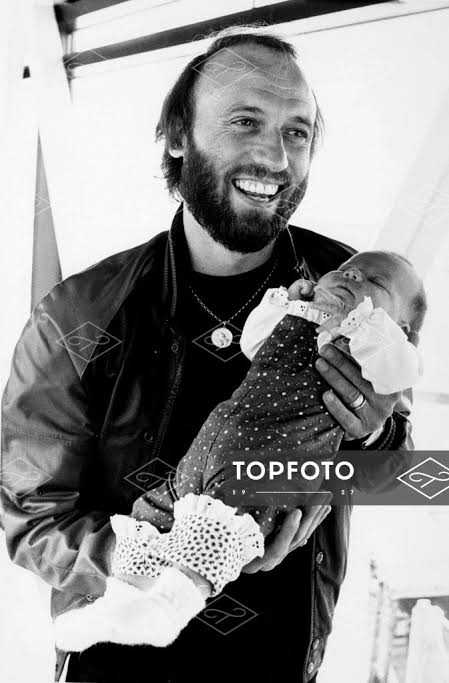 19th August 1980: Maurice Gibb of the Bee Gees with his 7-weeks old daughter,  Samantha at Heathrow Airport.He is to show off his new arrival - Topfoto  Image Archive
