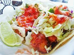 A couple of outdoor tables in the parking lot to sit. Monster Fish Tacos At Normita S Surf Taco Hb Food Finds