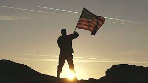 American flag with soldiers silhouette. Shutterstock