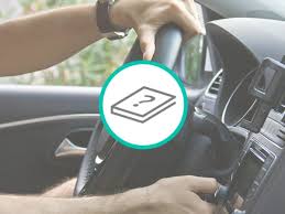 Man sitting in his car, holding a tablet, and looking over at his dog sitting in the passenger seat. How Much Does A Car Depreciate Per Year