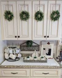 I Love This Idea For Neutral Christmas Decor Add Small Boxwood Wreaths To Your Kitchen Farmhouse Kitchen Decor Kitchen Cabinets Decor Rustic Farmhouse Kitchen