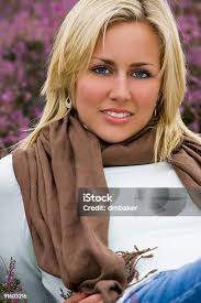 Beautiful Blond Woman Laying Down Smiling In Purple Heather Stock Photo