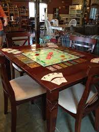 I Took A Monopoly Board And Some Game Pieces Glued Them To A Table Covered With Epoxy For Durability Then Recove Board Game Table Puzzle Table Board Games