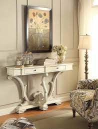 This console table features elegant spindle legs, a gracefully curved apron, and a single drawer with floral accents and hardware. Console Table Antique White Coaster Furniture Antique Furniture Living Room White Console Table