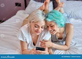 Positive Lesbian Couple Having Sun on Bed Using Smartphone, Watching Video  Stock Image - Image of lgbt, caucasian: 225394653