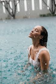 Woman In A Pool Swimming In The Rain By Jessica Sharmin For Stocksy United Rain Photography Pool Photography Swimming Pool Photography