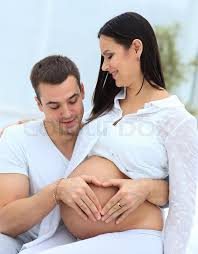 The husband hugs his pregnant beautiful wife, they spend time together on the bed in the bedroom. Closeup Husband And Pregnant Wife Stock Image Colourbox