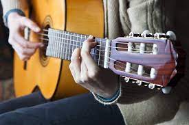 Hold your picking hand over the sound hole on your acoustic guitar or over the body if you are playing electric. How To Hold A Guitar Proper Posture And Hand Positioning Guitarhabits