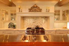 The shelves present some decor items, lights on either side of the range hood offer more light, and the backsplash finishes off this farmhouse look. Decorative Kitchen Hoods Both Functional And Beautiful