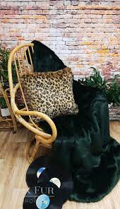 Simple living room design with extra touches that make it noteworthy such as dark green drapes, lamps on antique round wood tables in the corners and matching gold/green sofas. Forest Green Faux Fur Throw