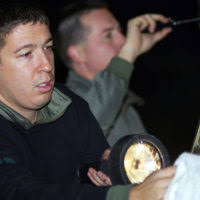 A maintenance crewman secures a screen over an engine intake