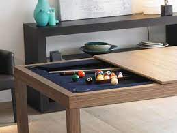 A closeup look at the pool table with yellow and purple balls situated behind the black sectional cozy basement offers brown leather couches with a wooden coffee table and a pool table on the side. Practical Furniture For Funny Evenings Dining And Coffee Table With Built In Games Pool Table Dining Table Home Decor Pool Table
