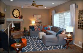Ficus next to brown sofa with orange cushions in grey living room interior. Blue Grey And Brown Casual Living Room Blue Living Room Blue Orange Gray Casual Living Gray Living Room Orange Blue And Orange Living Room Blue Family Rooms