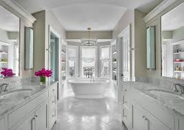 Chic bathroom boasts a danville sphere chandelier over a freestanding tub placed in front of windows dressed in gray drapery panels. Coldwell Banker Global Luxury Blog Luxury Home Style