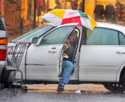 Harry Anderson tries to stay relatively dry as he maneuvers his umbrella  into position before slipping out of his car during a steady rainstorm,  Thursday, Dec 27, 2018, in Baton Rouge, La.