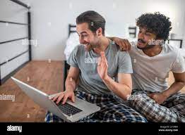 Gay men using their laptop for Skype communication Stock Photo - Alamy
