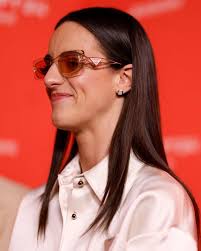 Caitlin Clark Showed Up To Tonight's Clash vs. Angel Reese With A Dress  That Was So Short, She Needed Her Hand To Keep It From Showing Too Much