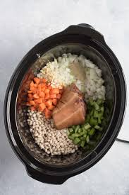 Put the rinsed beans, garlic, onion, salt, pepper, parsley, cloves, ham (chopped into large chunks) or ham hocks into the crock pot along with 6 cups water or broth. Slow Cooker Ham And Bean Soup Recipe Wholefully