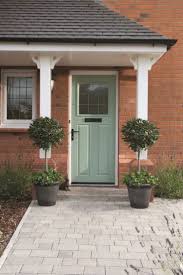 A Charming Front Door In A Vintage Shade Of Green The Trees Either Side Of The Doorway Echo The Symet Front Doors Uk Traditional Front Doors Front Door Porch