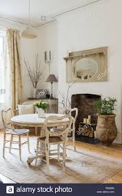 Runder tisch mit aufbewahrungsfach und 2 stuhlen naturfarben weiss runder tisch mit stühlen unique stühle. Weisser Runder Tisch Und Rattan Stuhle In Hellen Und Geraumigen Aufenthaltsraum Stockfotografie Alamy