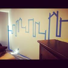 A batman bed can be the centerpiece in the bedroom. Painting Gotham City Accent Wall Superhero Room Superhero Room Batman Room Kids Room