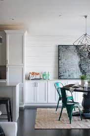 Beside A White Cottage Kitchen A Round Black Wood Dining Table Seats Emerald Green Tolix Chairs On A Built In Buffet Cottage Dining Rooms Dining Room Remodel
