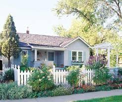See more ideas about white picket fence, picket fence, fence. Blooming Shrubs And A White Picket Fence Accent This Home S Cottage Style See More Front Yard Flower Gardens Http Ww Front Garden Cottage Garden Front Yard