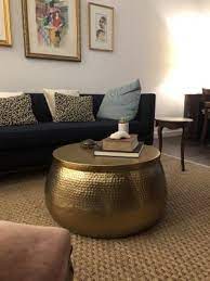 Hammered coffee table with pretty decor. Round Gold Hammered Metal Cala Coffee Table Metal Table Decor Cocktail Tables Living Room Coffee Table
