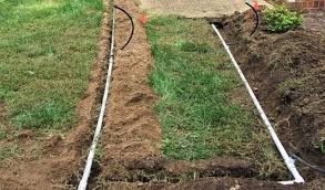 Technician installing sprinkler system in residential yard