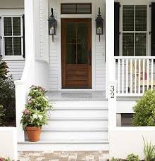 Black And White House With Wood Garage Door White House Black Shutters Wooden Steps House Exterior Porch Design White House Black Shutters
