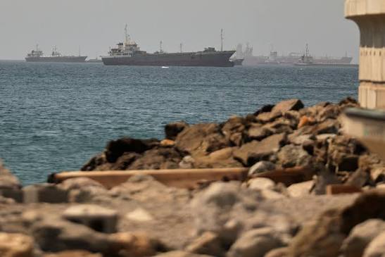A view of an oil tanker navigating the strategic Strait of Hormuz amidst increased military presence.