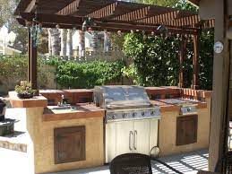 A masonry grill station of eden veneer with a cut bluestone coping surrounds a profire gas grill, side burners, trash and recycling pull out and outdoor faucet. Great Plans For The Backyard Diy Grill Station Designs And Ideas