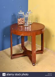 Handgefertigter couchtisch aus beton 80 durchmesser betonmobel. Retro Mobeln Stillleben Mit Kleinen Runden Holz Beistelltisch Mit Sammlung Von Drei Glasern One Mit Nussen Im Raum Mit Blauen Und Gelben Wanden Stockfotografie Alamy