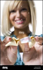 Woman opening fortune cookie Stock Photo