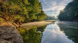 A large natural stream of water emptying into an ocean, lake, or other body of water and. Duck River
