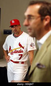 Third baseman Mark DeRosa (L) waits as St. Louis Cardinals General Manager  John Mozeliak talks with members of the media before introducing DeRosa as  a new member of the club in St. Louis