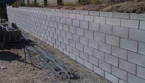 Concrete blocks are ideal for building walls to hold back the soil after you dig into a slope for a pathway, patio, or another landscaping project. Construction Of Concrete Block Retaining Walls With Steps