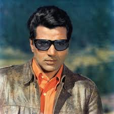 Dharmendra Portrait in a Orange Shirt and Brown Jacket with Gogles- still  from the movie “Lalkar”