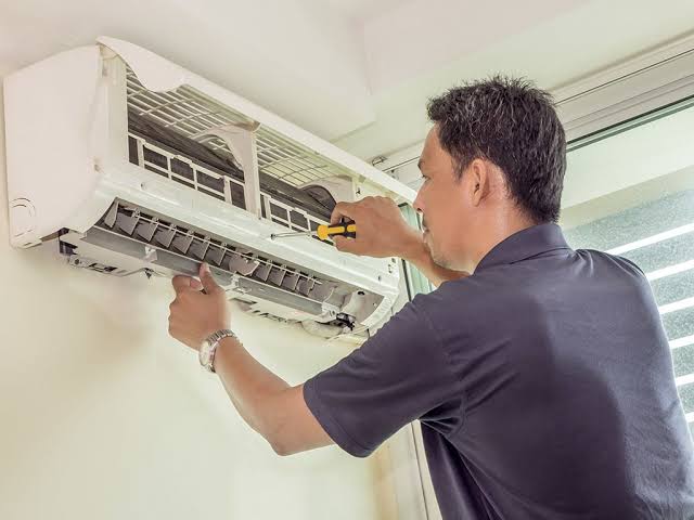 Technician checking AC outdoor unit